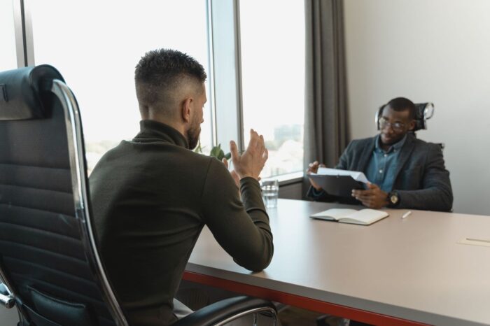 Kandidaat bespreekt werkcultuur met een interviewer aan tafel