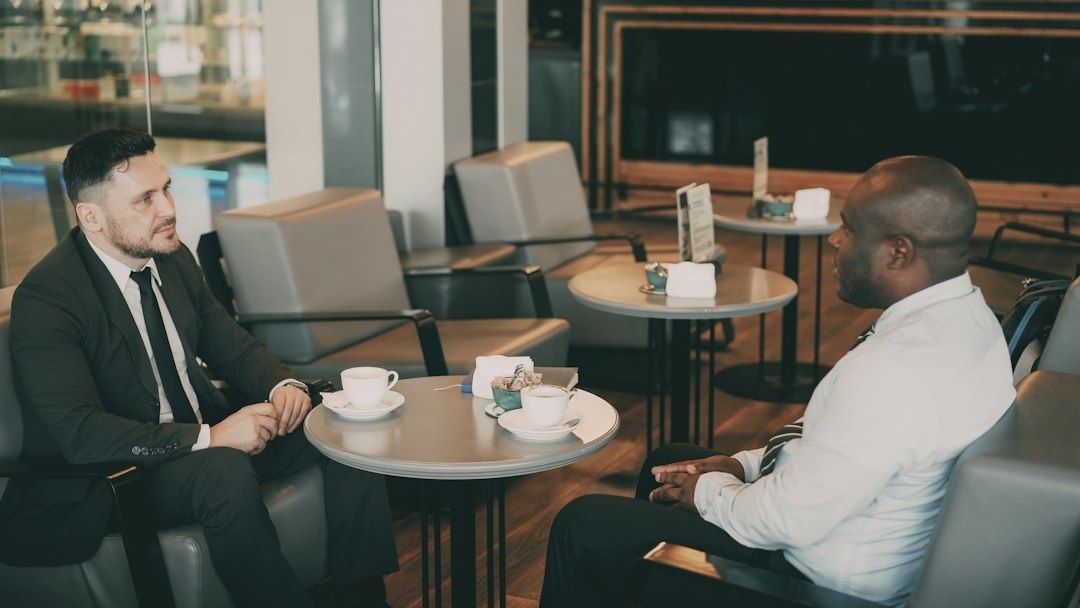 Twee mannen bespreken zakelijke kleding in een café tijdens een gesprek